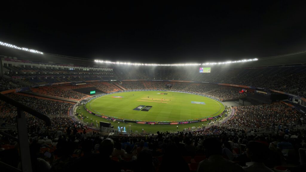 A captivating night cricket match with a large crowd at Narendra Modi Stadium in Ahmedabad, India.